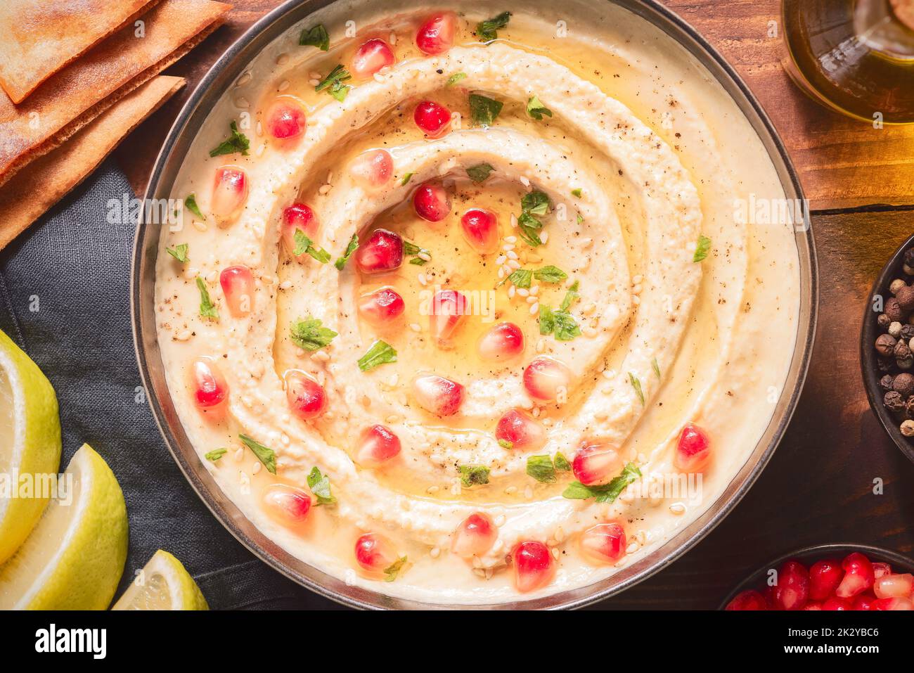 Arabic cuisine; Traditional creamy hummus dip in dark bowl. Topped with