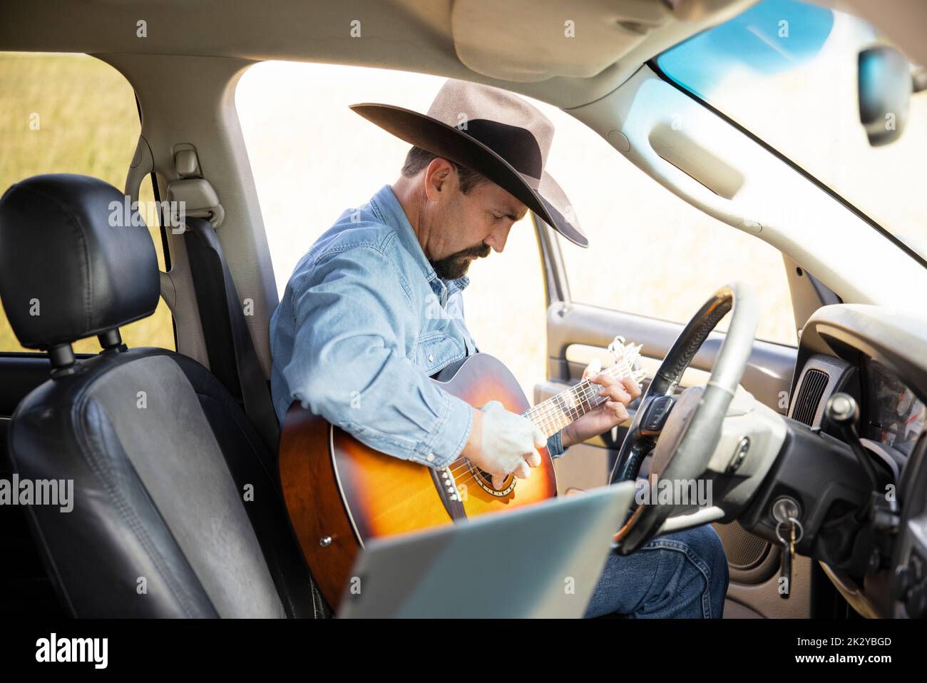 Cowboy playing guitar in pickup truck Stock Photo - Alamy