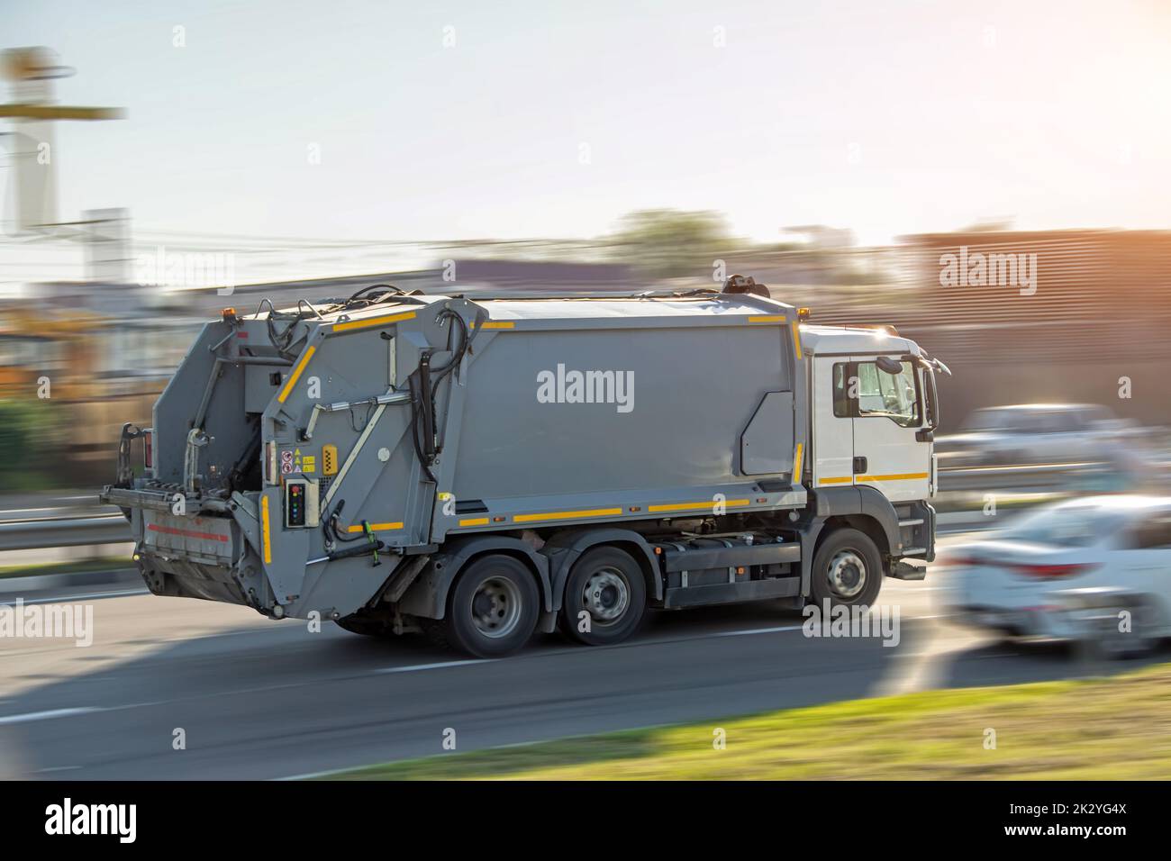 Recycling gray garbage truck driving on highway with motion blur speed effect Stock Photo