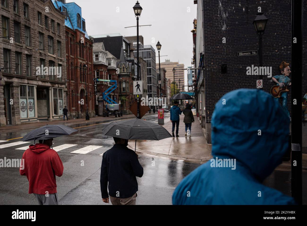 Canada. 23rd Sep, 2022. Pedestrians shield themselves from heavy rain