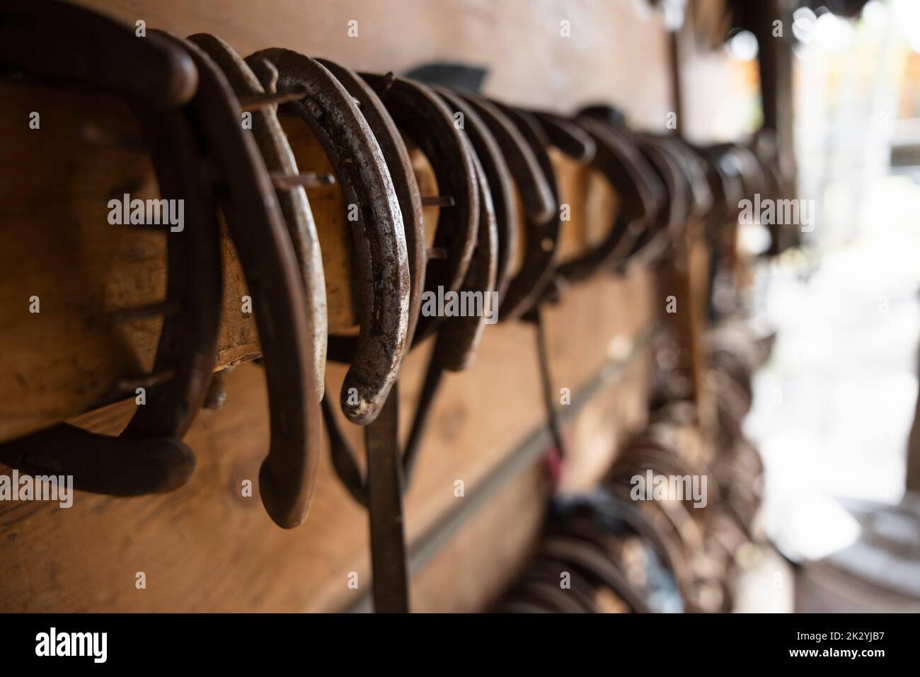 Horseshoes hanging from rack in stable tack room Stock Photo Alamy