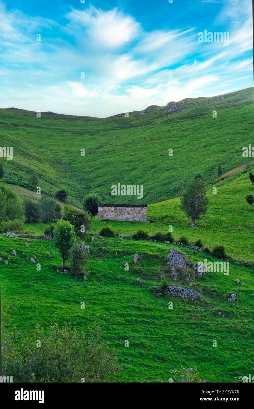 An aerial view of lush green countryside with hills under blue cloudy ...