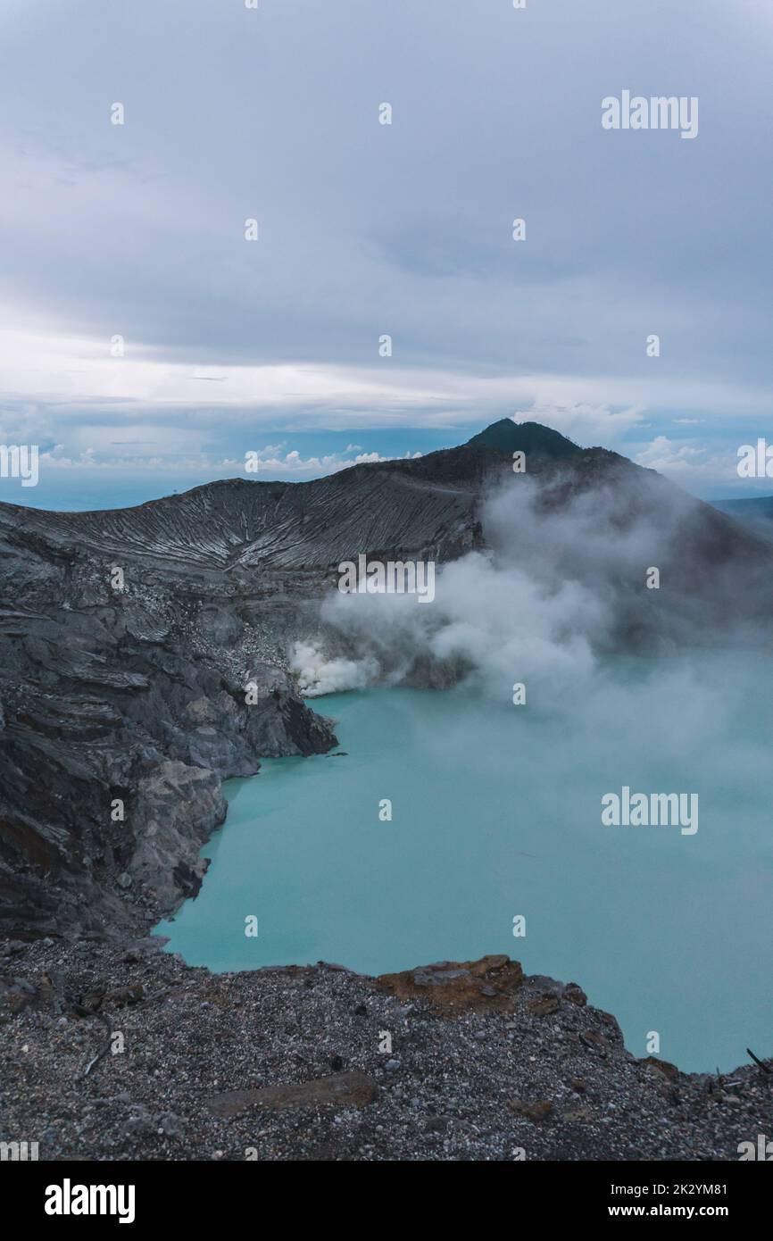A vertical aerial view of a blue acid lake with sulfur steam near Mount ...