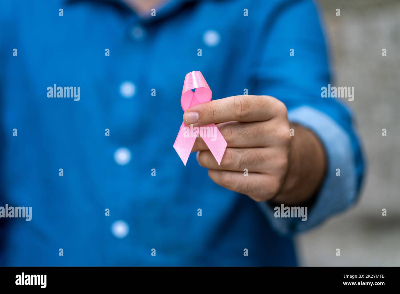 man posing he holding pink ribbon for supporting people living and illness,  Breast Cancer Awareness concept Stock Photo
