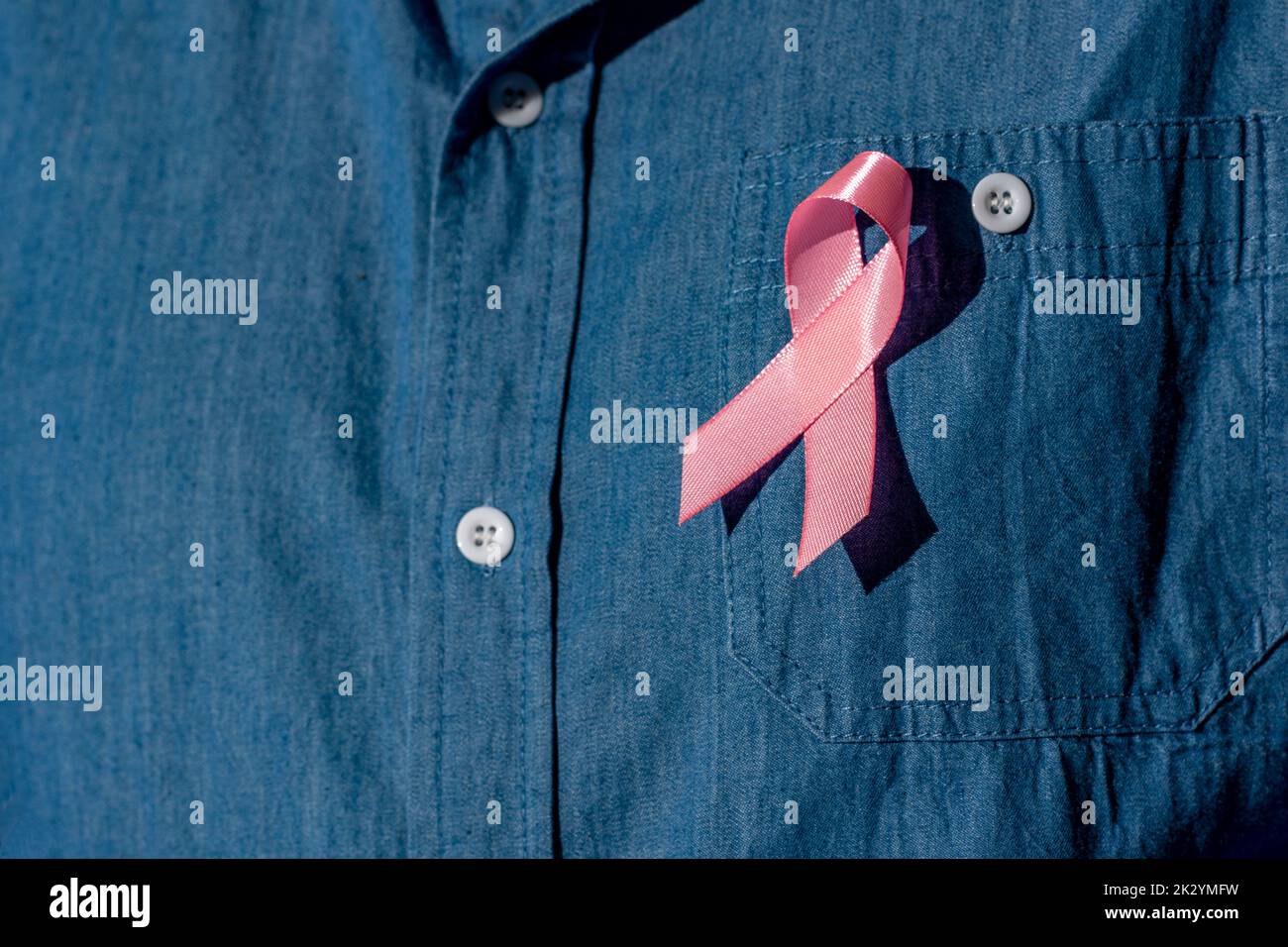 man posing he holding light pink ribbon for supporting people living and illness,  Breast Cancer Awareness concept Stock Photo