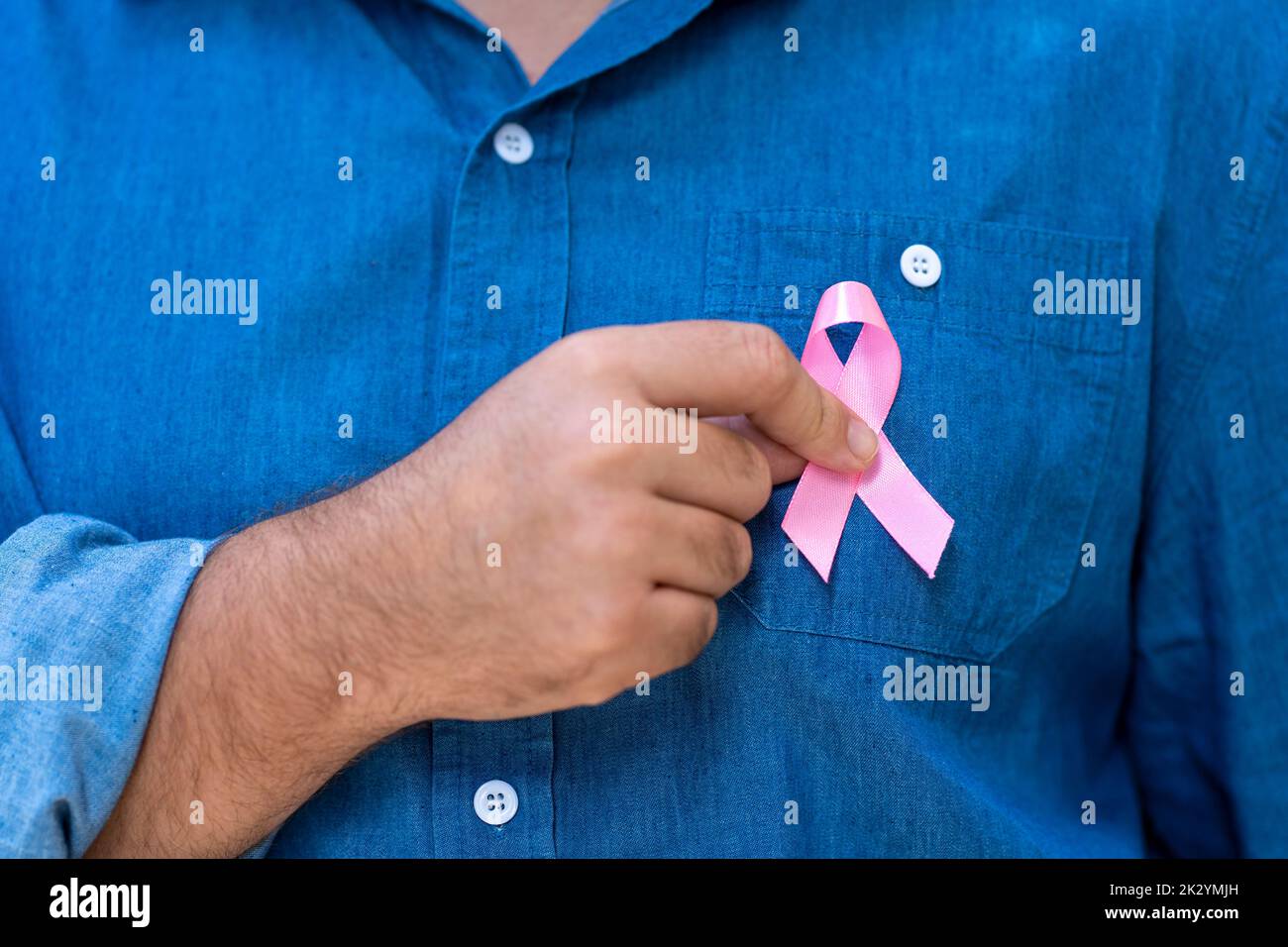 man with pink ribbon for supporting people living and illness,  Breast Cancer Awareness concept Stock Photo