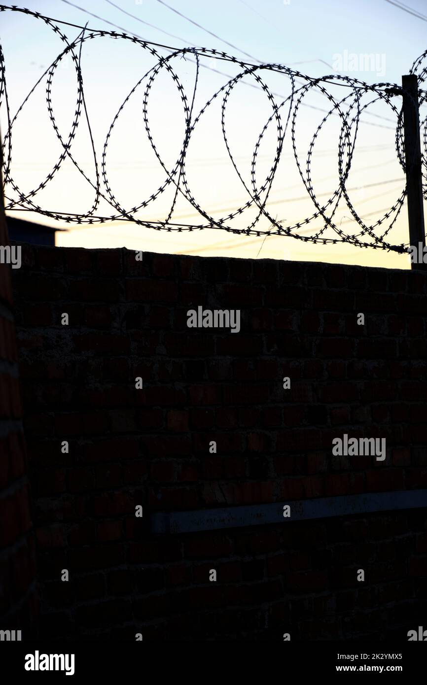 Fence with barbed wire background sky during sunset Stock Photo - Alamy