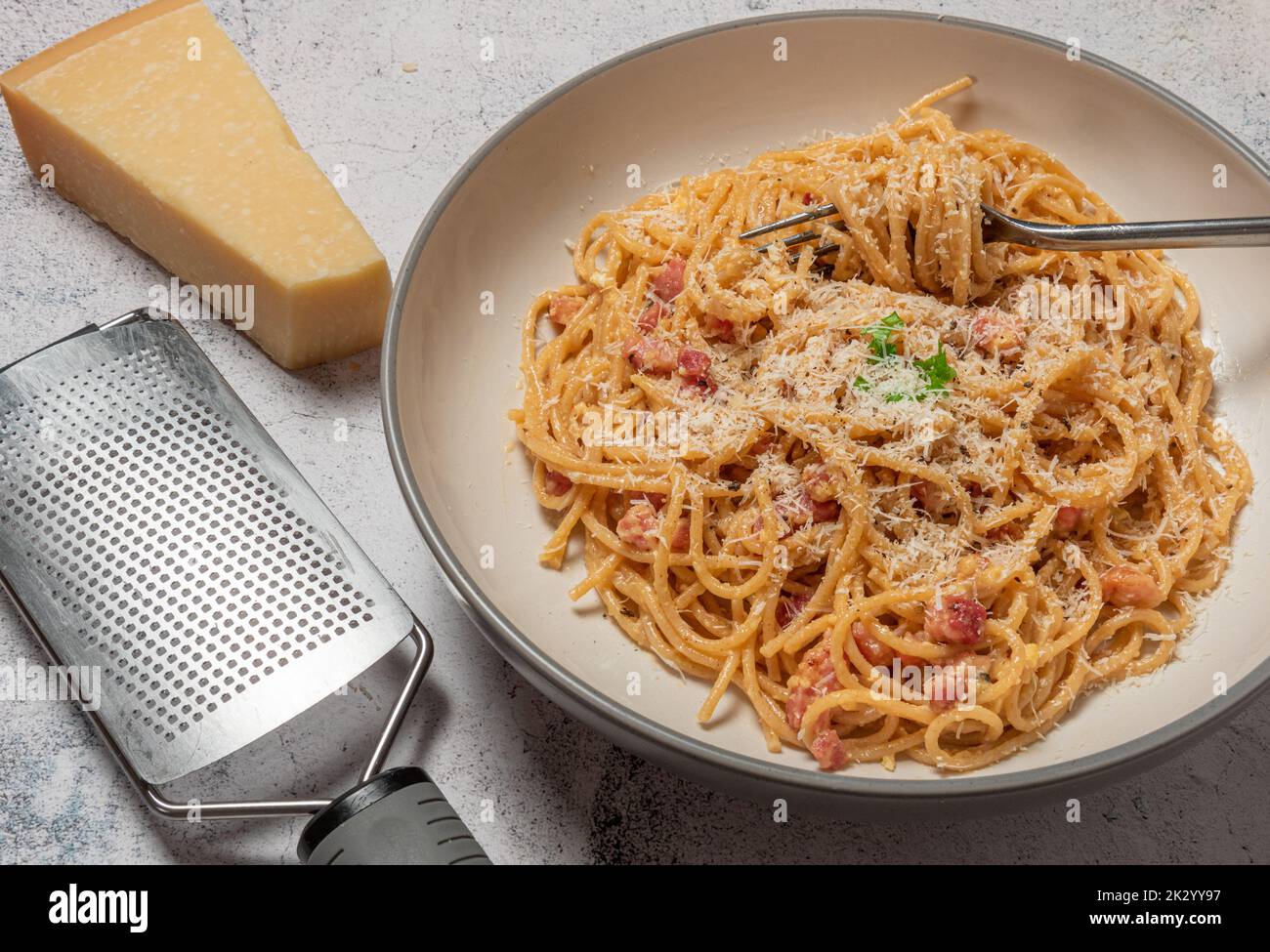 Spaghetti carbonara with parmesan grater Stock Photo