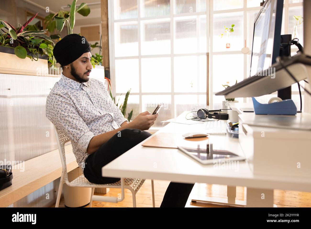 Architect of startup business using phone at workstation Stock Photo
