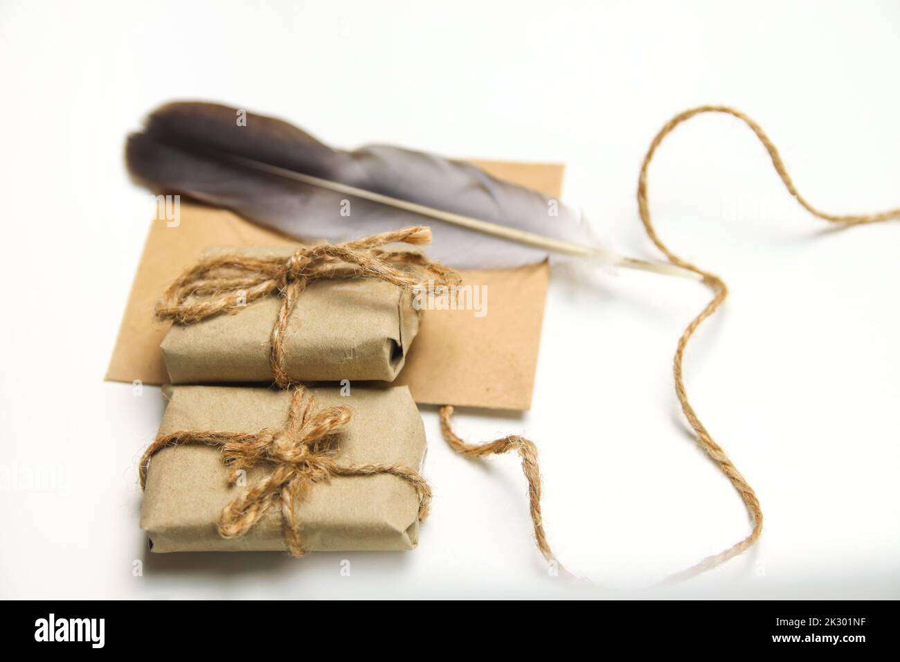 Defocus craft eco rope and envelope, feather pen on white background. Christmas holiday concept. Letter to Santa Claus. Wish list. Old quill pen. Retr Stock Photo