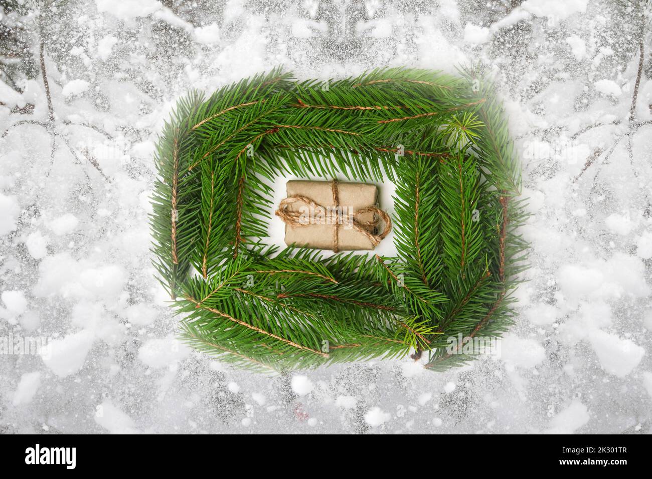 Defocus Christmas gift on green fir natural background and white snowy background. Eco craft gift boxes. Organic eco craft Christmas tree. Creative ar Stock Photo