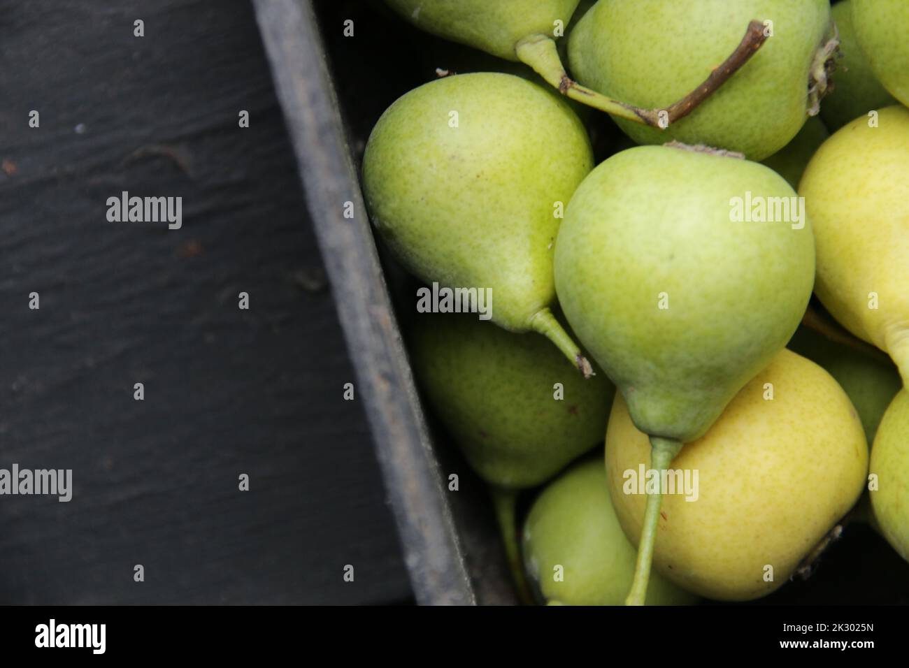 Ripe pears in a box on the table. Place for text. Stock Photo