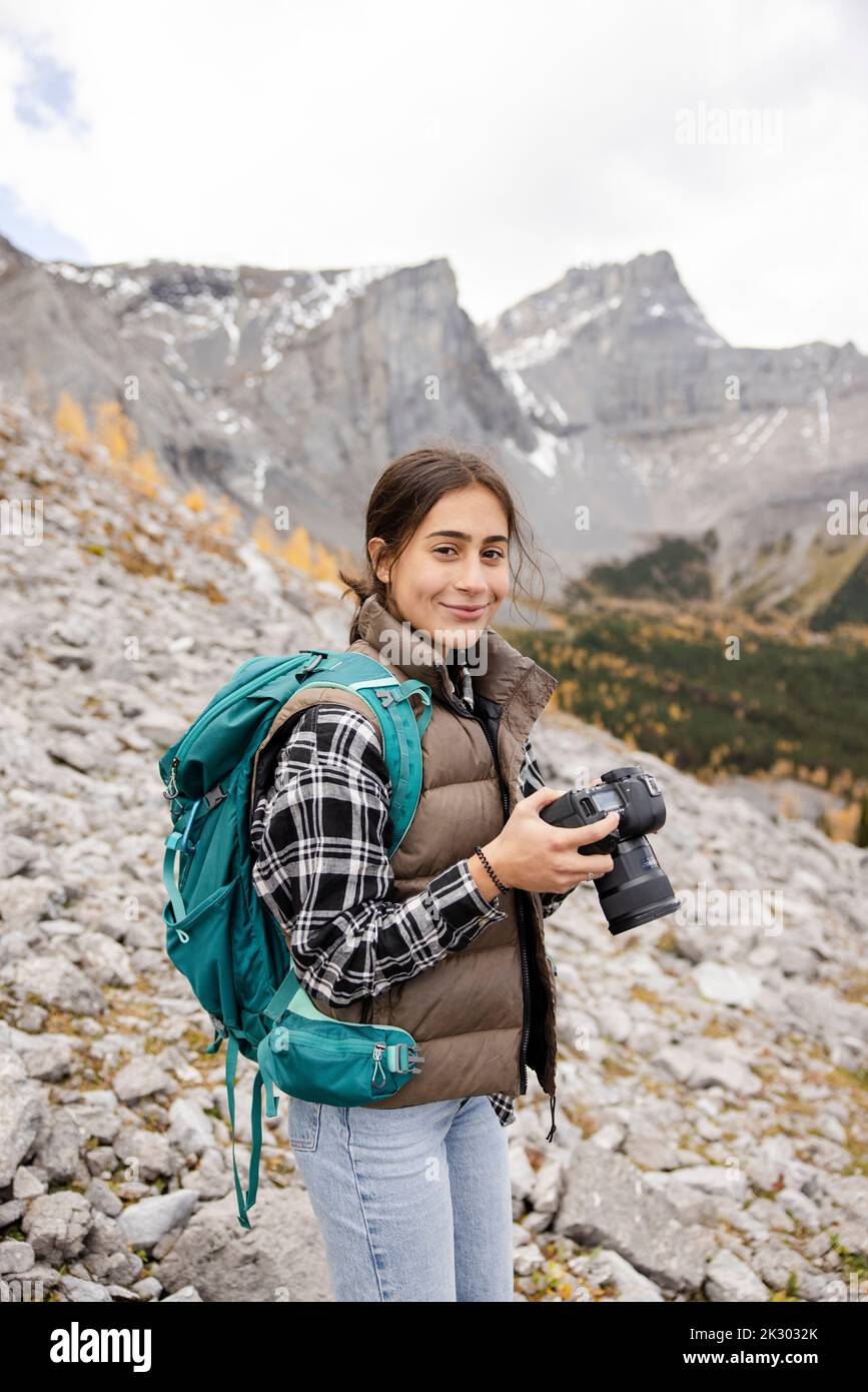 Teenage girl hiking backpack in craggy rocky mountains hires stock