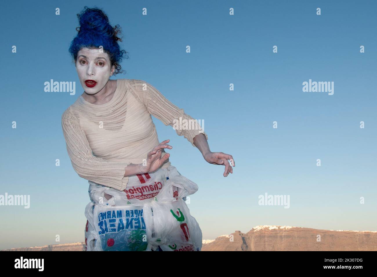 A woman mimes against the blue sky during a performance on the island of Santorini in Greece Stock Photo