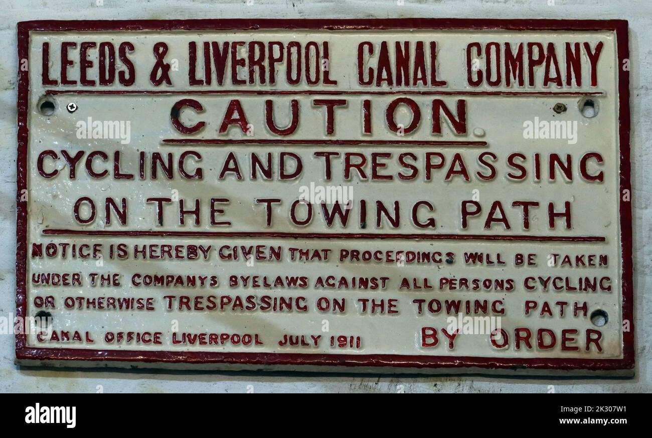 Leeds & Liverpool canal company cast iron sign, caution, cycling and trespassing, on the towing path Stock Photo