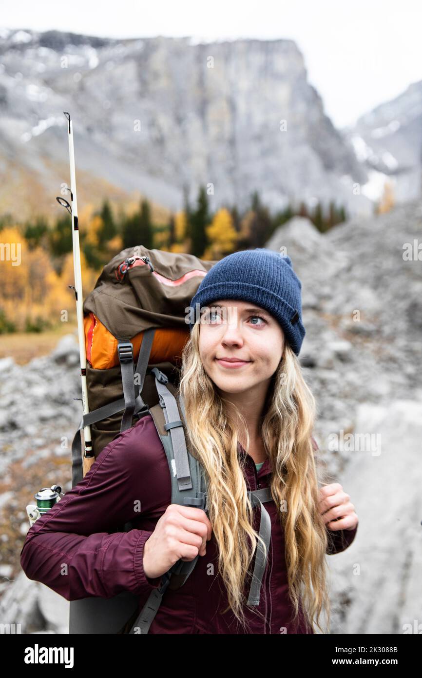 Serene young female backpacker hiking in autumn mountains Stock Photo