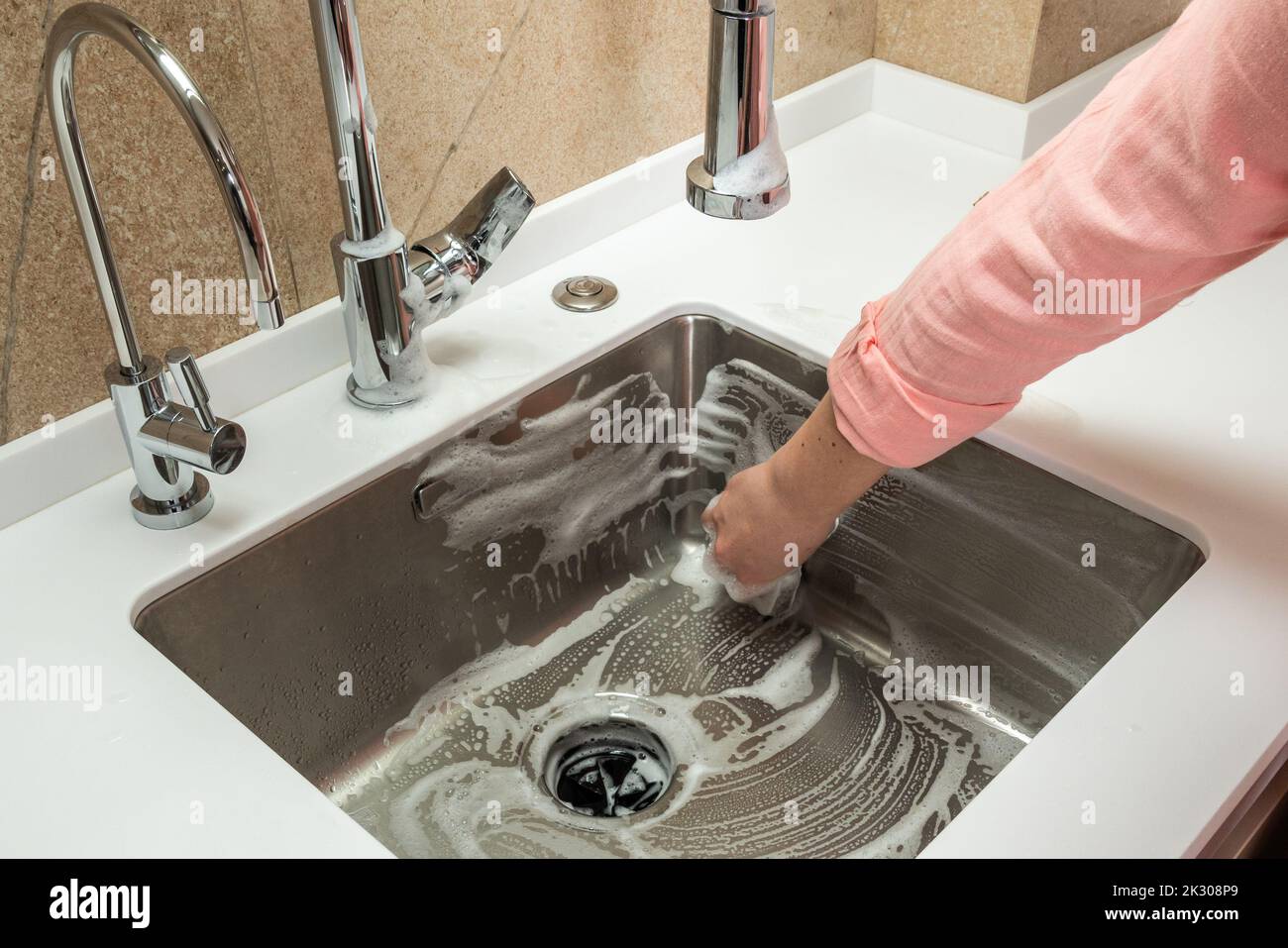 Rinsing the foam cleaner from the kitchen sink Stock Photo