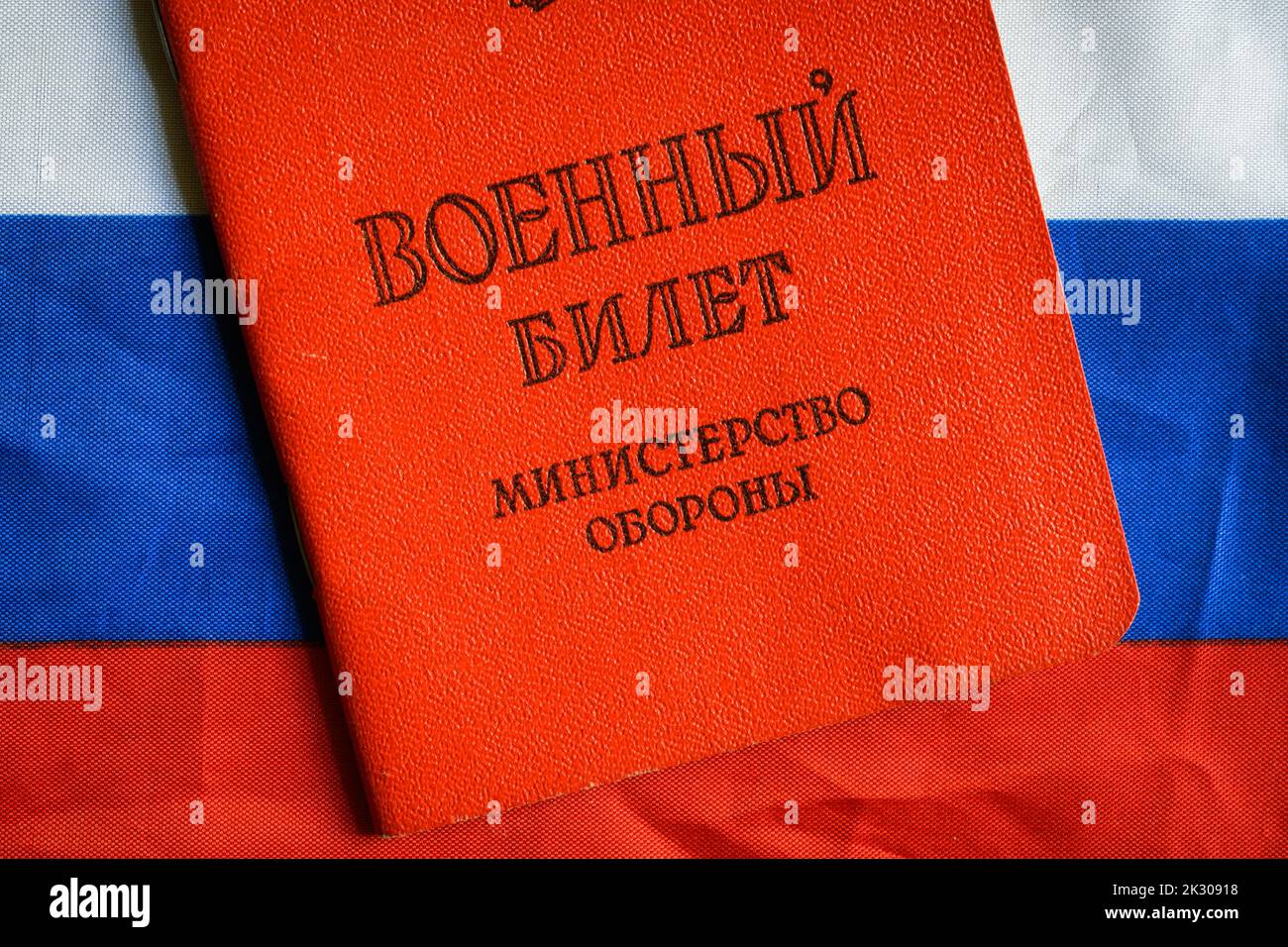 Certificate of Russia serviceman on Russian flag on table, top view. Concept of mobilization, war in Ukraine, soldier, duty and army. Translation: Mil Stock Photo