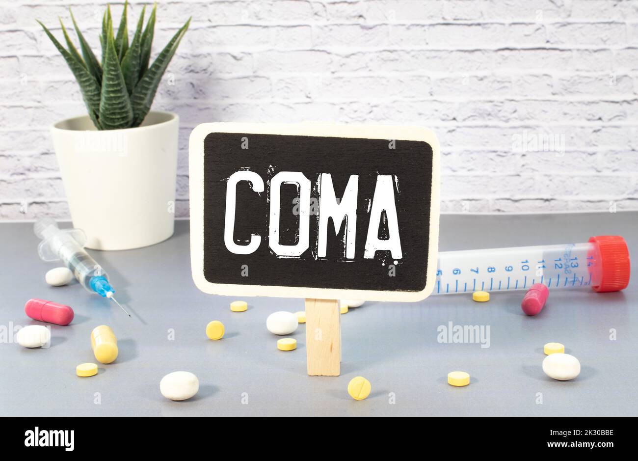 Card with word Coma, pills, gloves and surgical masks on wooden table, flat lay Stock Photo