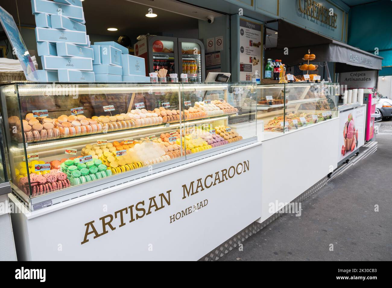 Paris, France - August 26 2022: Macaron shop in the streets of Paris. Assortment of different flavours of almond cookies, sandwiches, crepes. Stock Photo