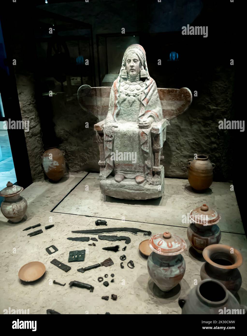 Lady at Baza. 350 BC. Sculpture and goods from grave 155 at Baza Basti, Baza, Granada, Spain. Sculpture of Baza Woman on throne used as cinerary Stock Photo