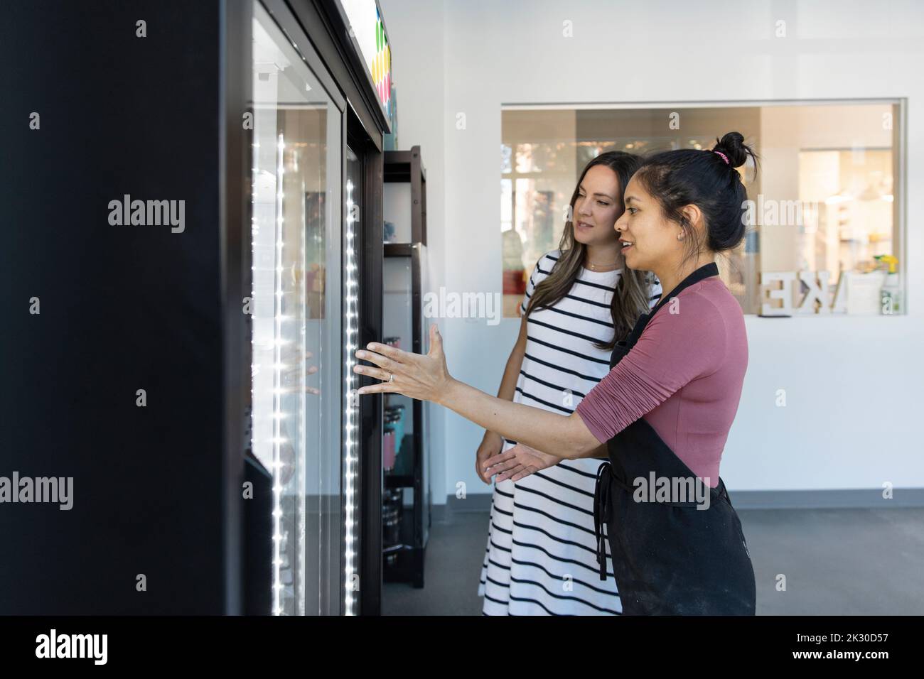Small business owner and customer looking in refridgerator Stock Photo
