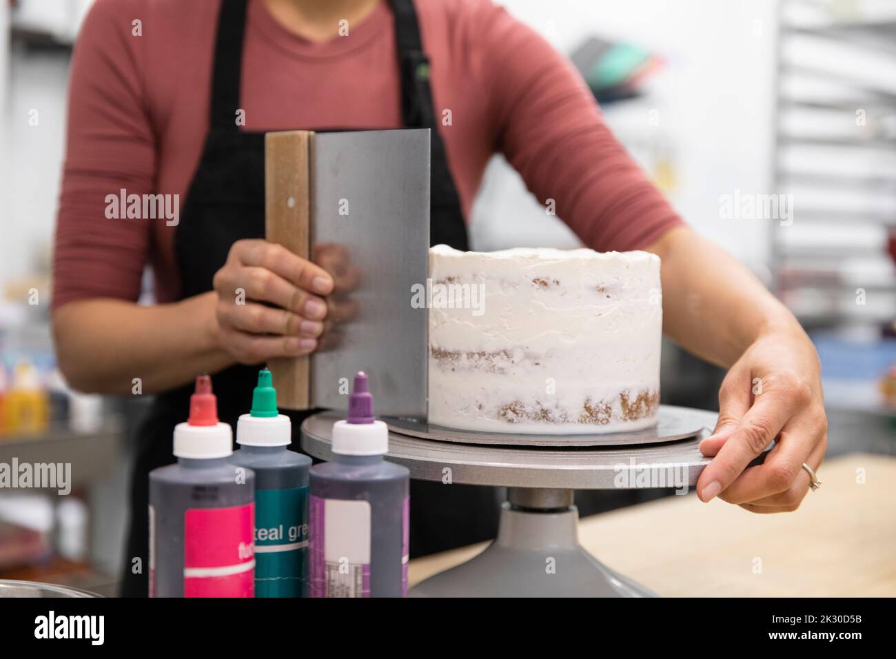 Woman smoothing icing on handmade cake closeup Stock Photo