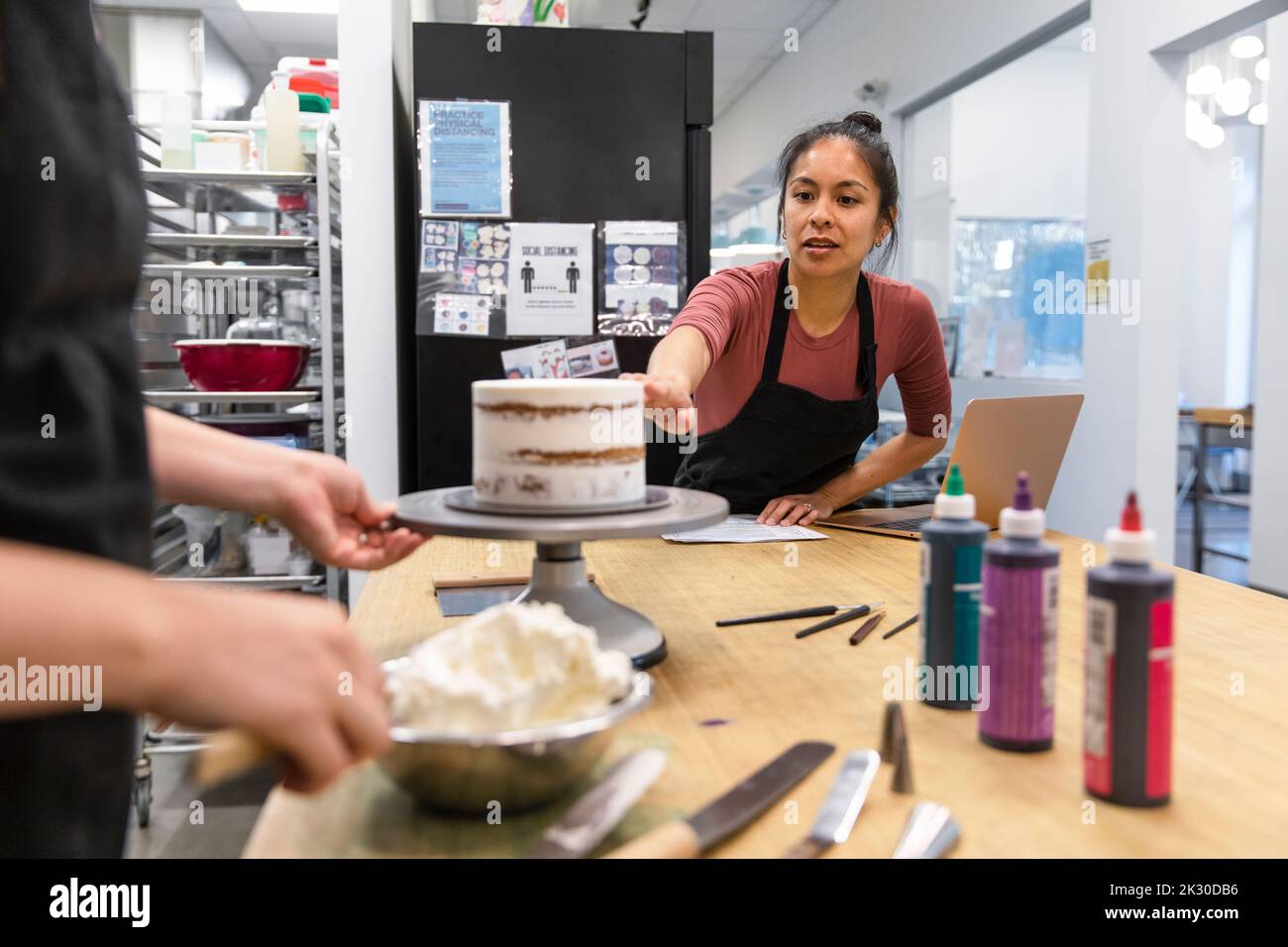 Woman teaching baking intern in small business Stock Photo