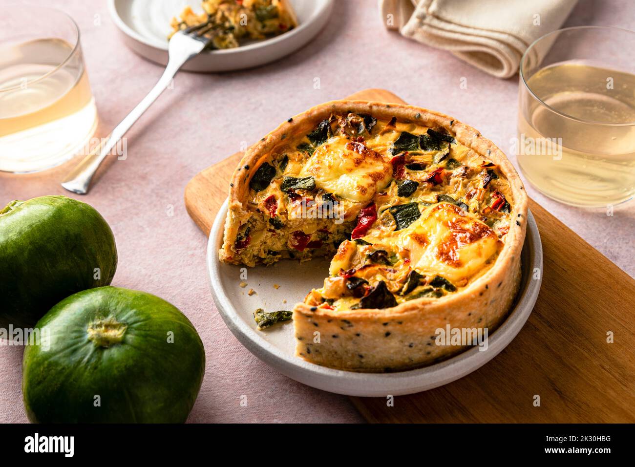 Studio shot of freshly baked zucchini quiche with red bell pepper and onion Stock Photo