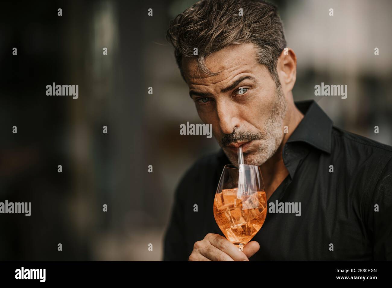 Handsome mature man drinking with straw Stock Photo
