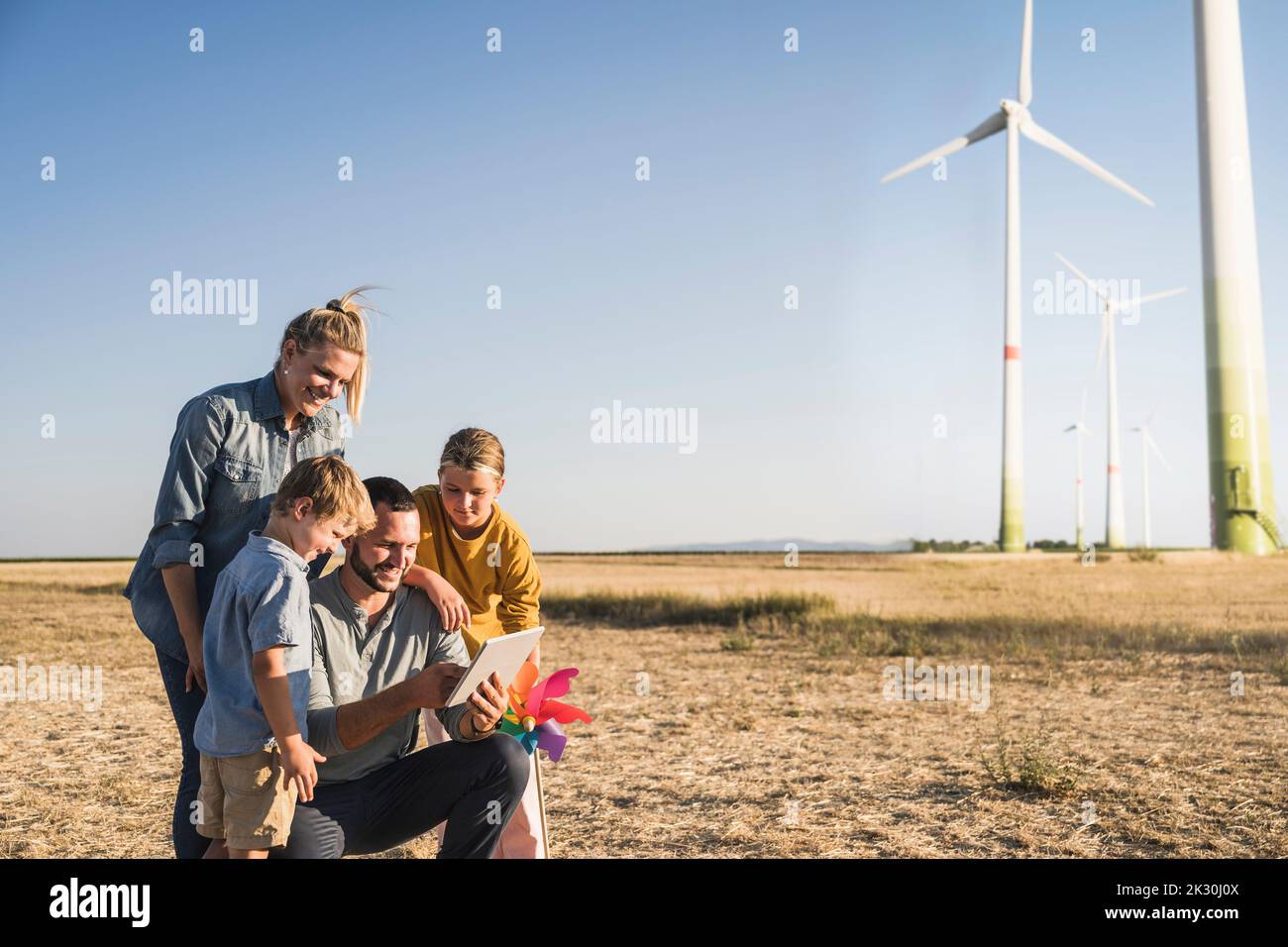 Smiling family using digital tablet in wind park Stock Photo