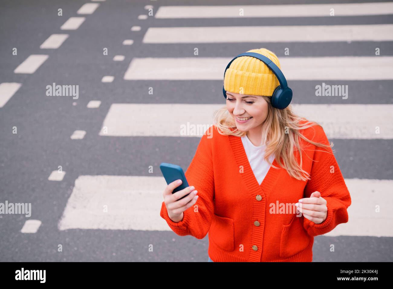 Crosswalk accident. Pedestrian with smartphone and headphones