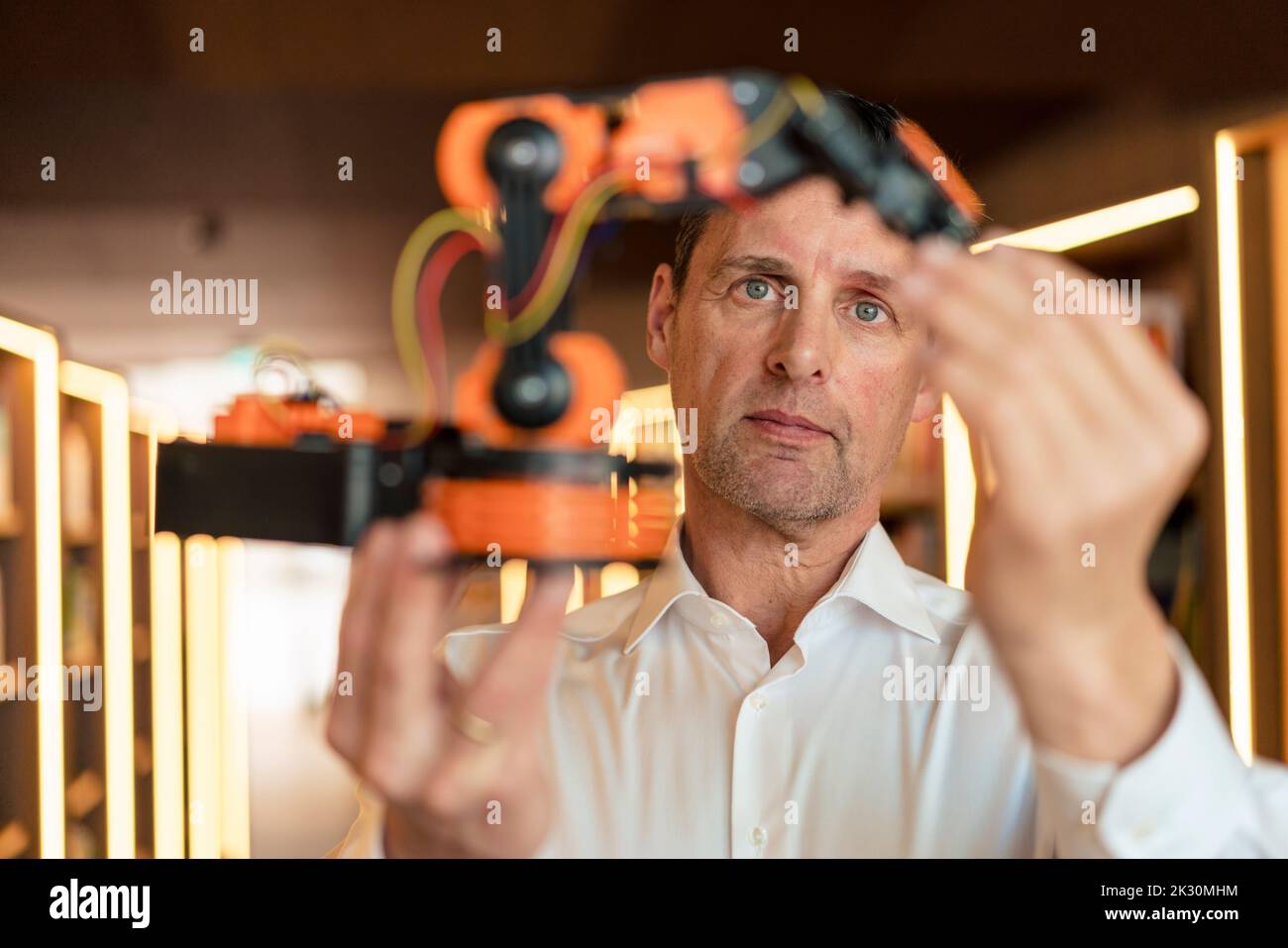 Technician examining robotic arm at workshop Stock Photo