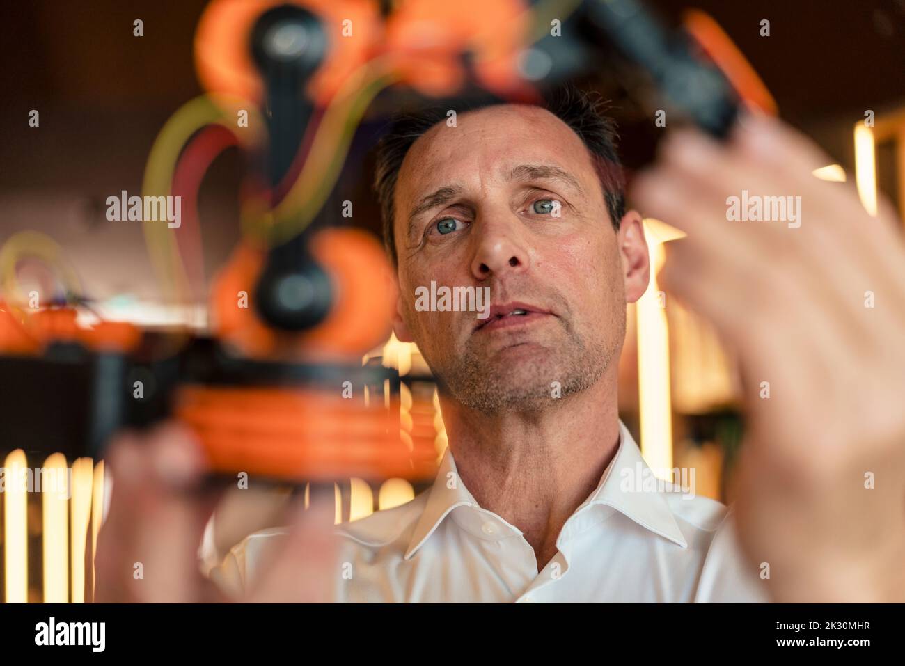 Engineer looking at robotic machine at workshop Stock Photo