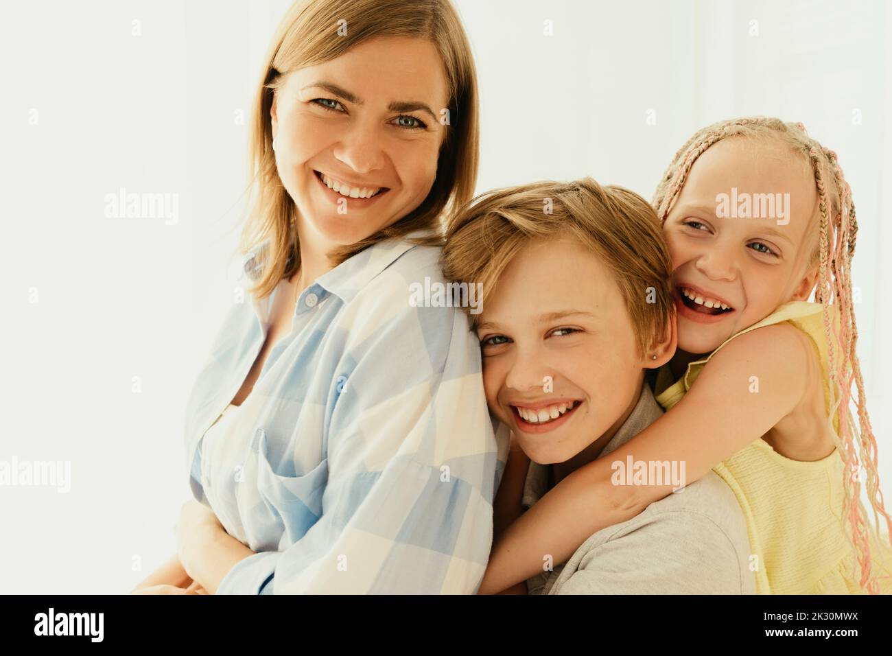 Happy mother with son and daughter spending time together at home Stock Photo
