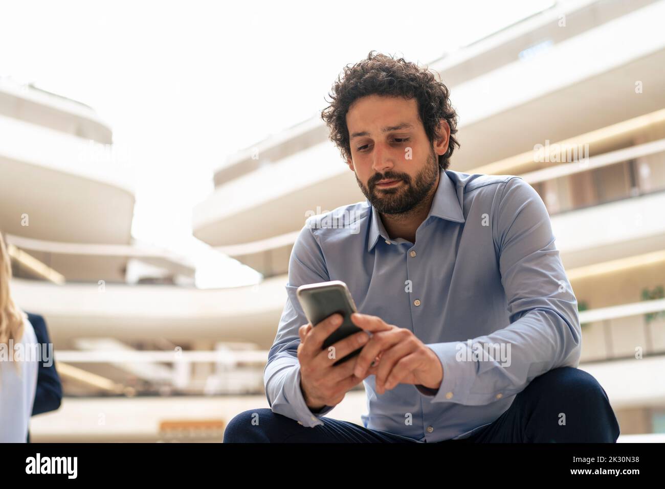 Businessman text messaging through mobile phone in office Stock Photo