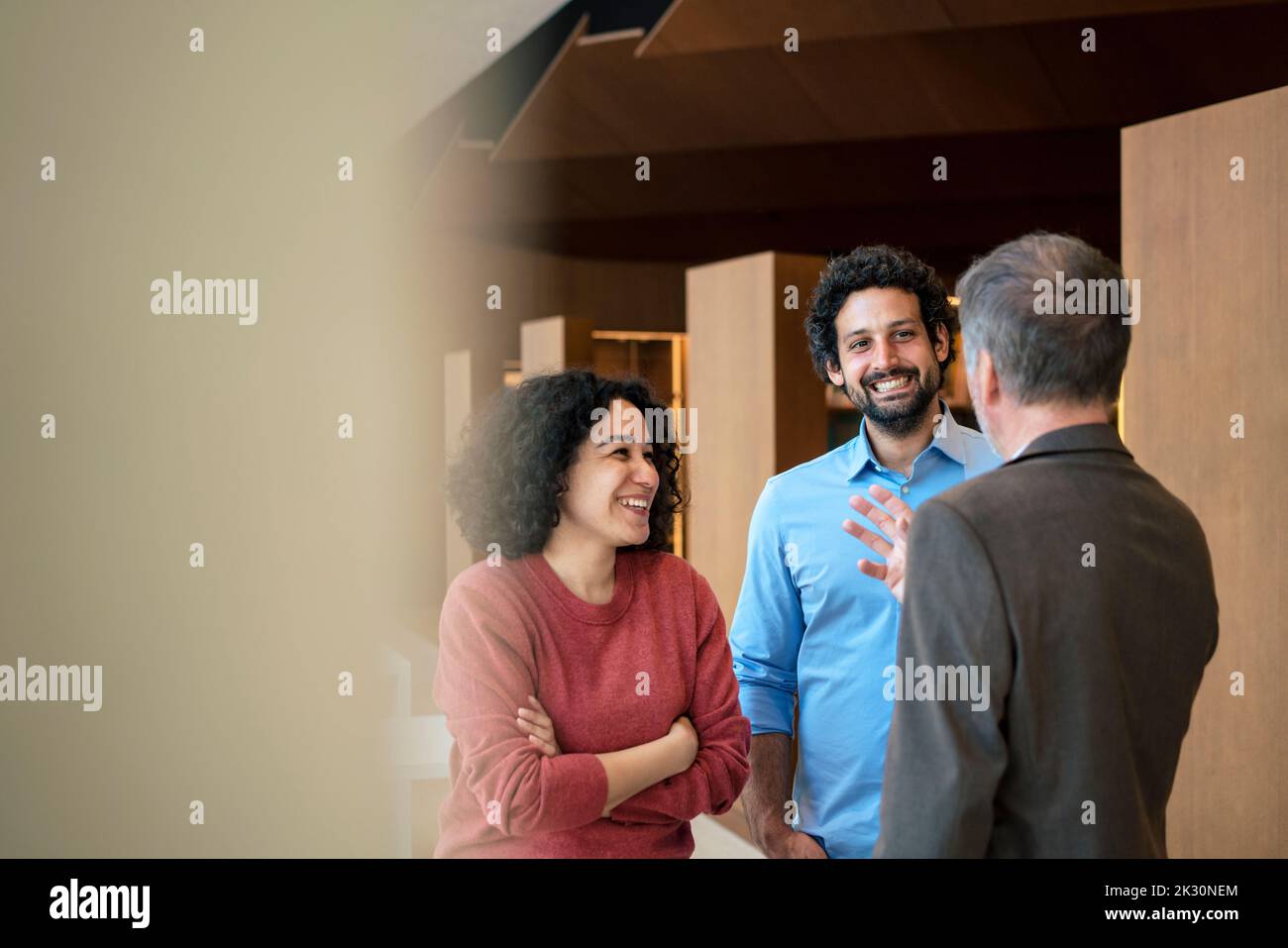Happy multiracial colleagues discussing in office Stock Photo - Alamy