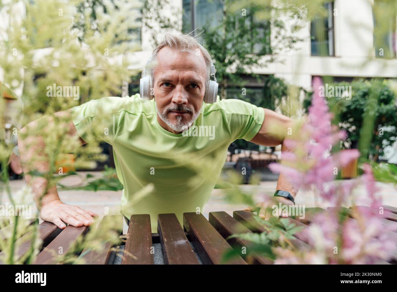 Man wearing headphones doing push-ups Stock Photo