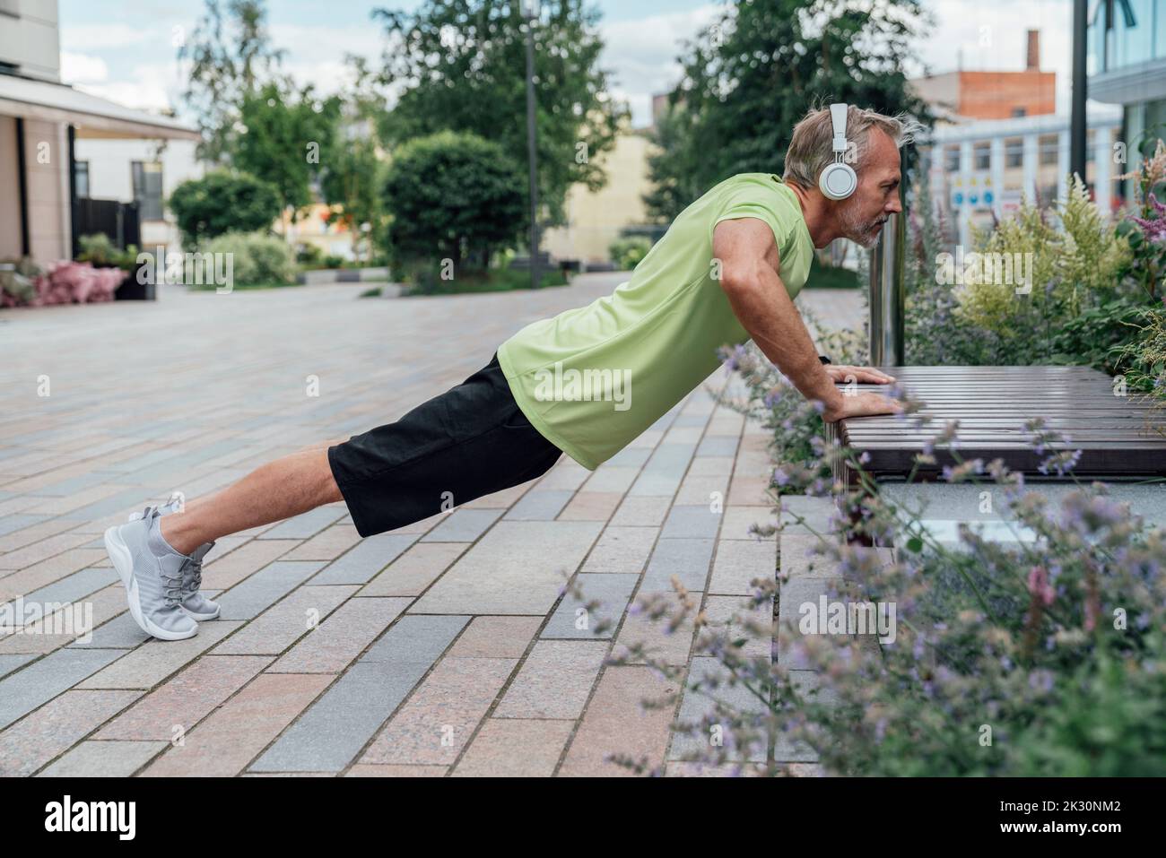 Mature man doing push-ups on bench Stock Photo