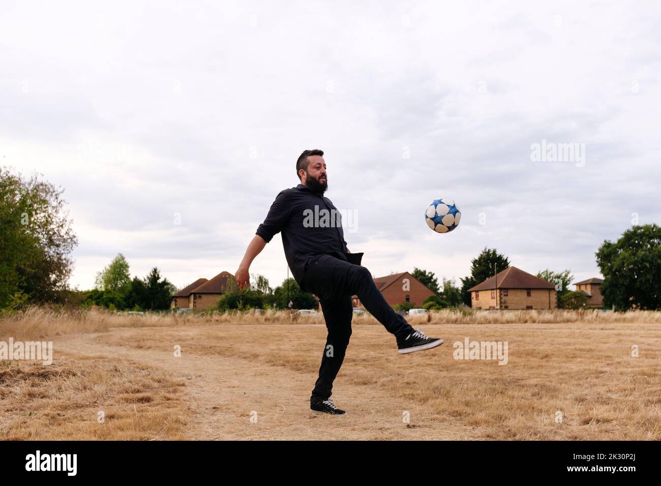 Mature man playing with soccer ball in field Stock Photo - Alamy