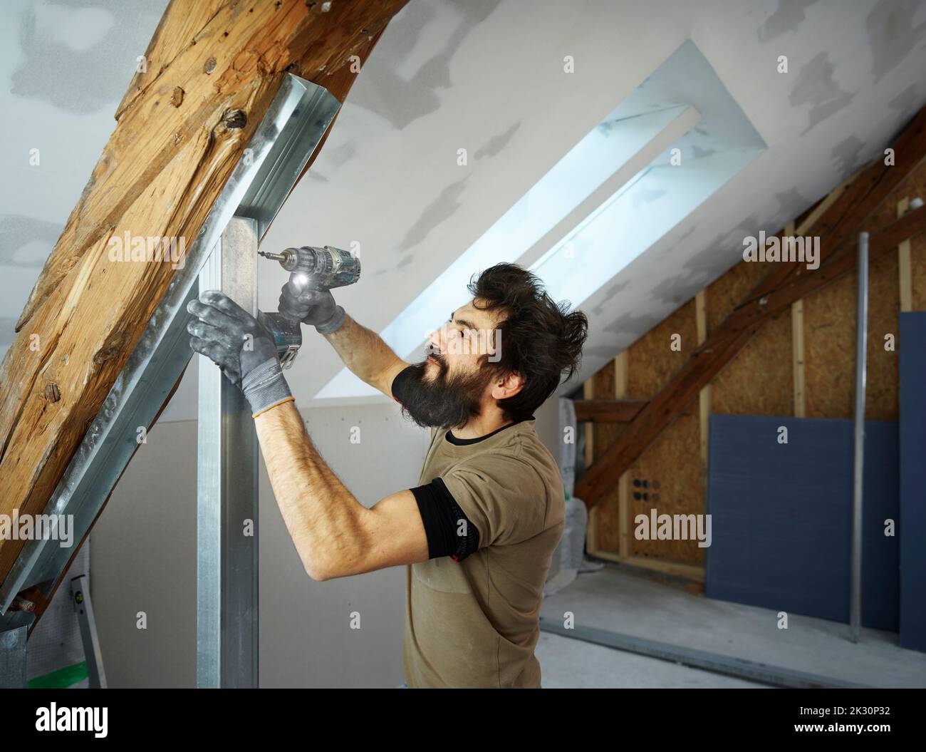 Construction worker using drill on metal at site Stock Photo