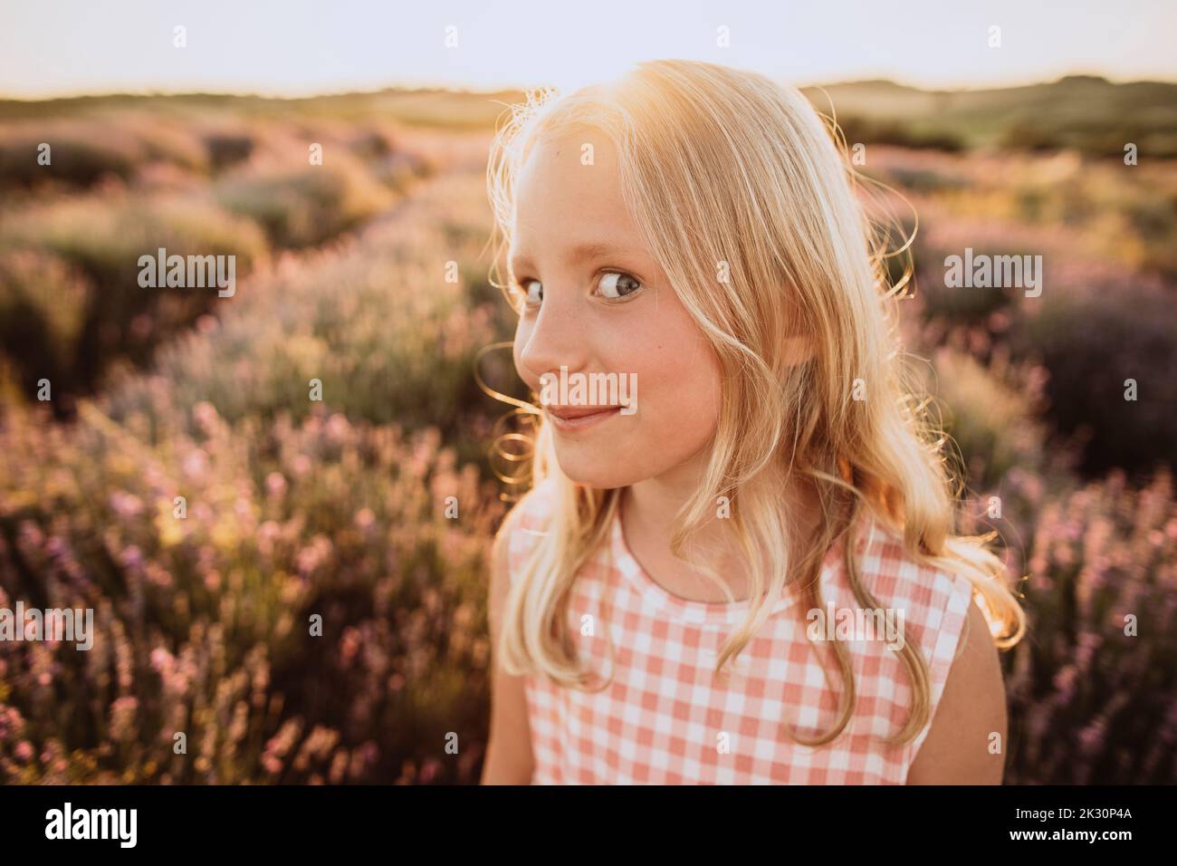 Girl with blond hair making facial expression in lavender field on sunset Stock Photo