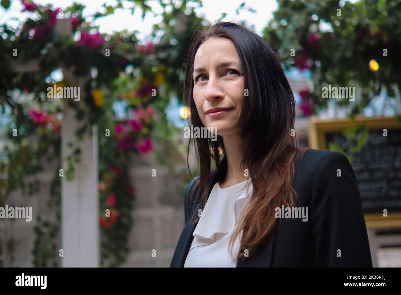 Thoughtful mature businesswoman standing outside restaurant Stock Photo
