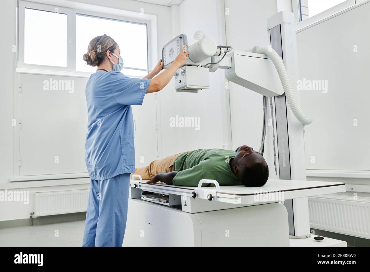 Nurse adjusting Xray machine for patient in clinic Stock Photo Alamy