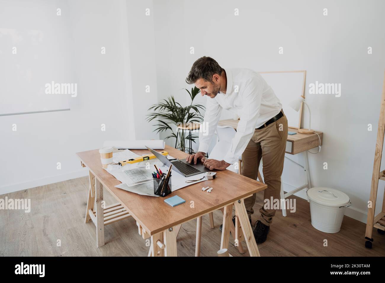 Architect using laptop at desk in office Stock Photo