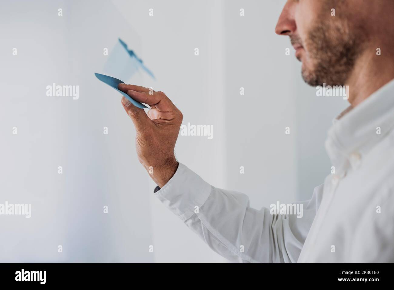 Hand of businessman sticking adhesive note on glass Stock Photo