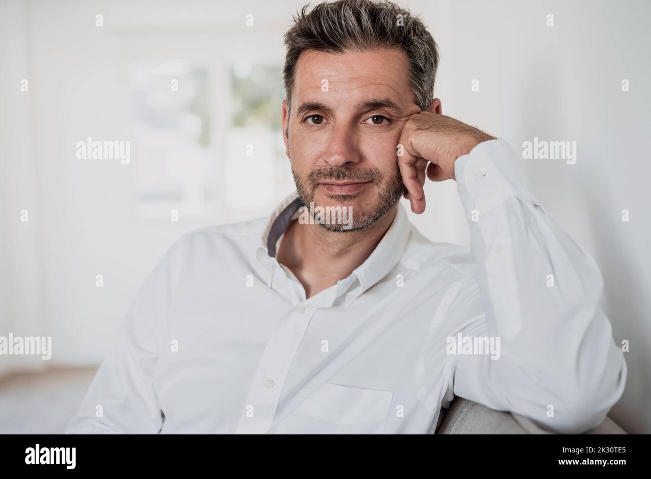 Smiling businessman on sofa in office Stock Photo