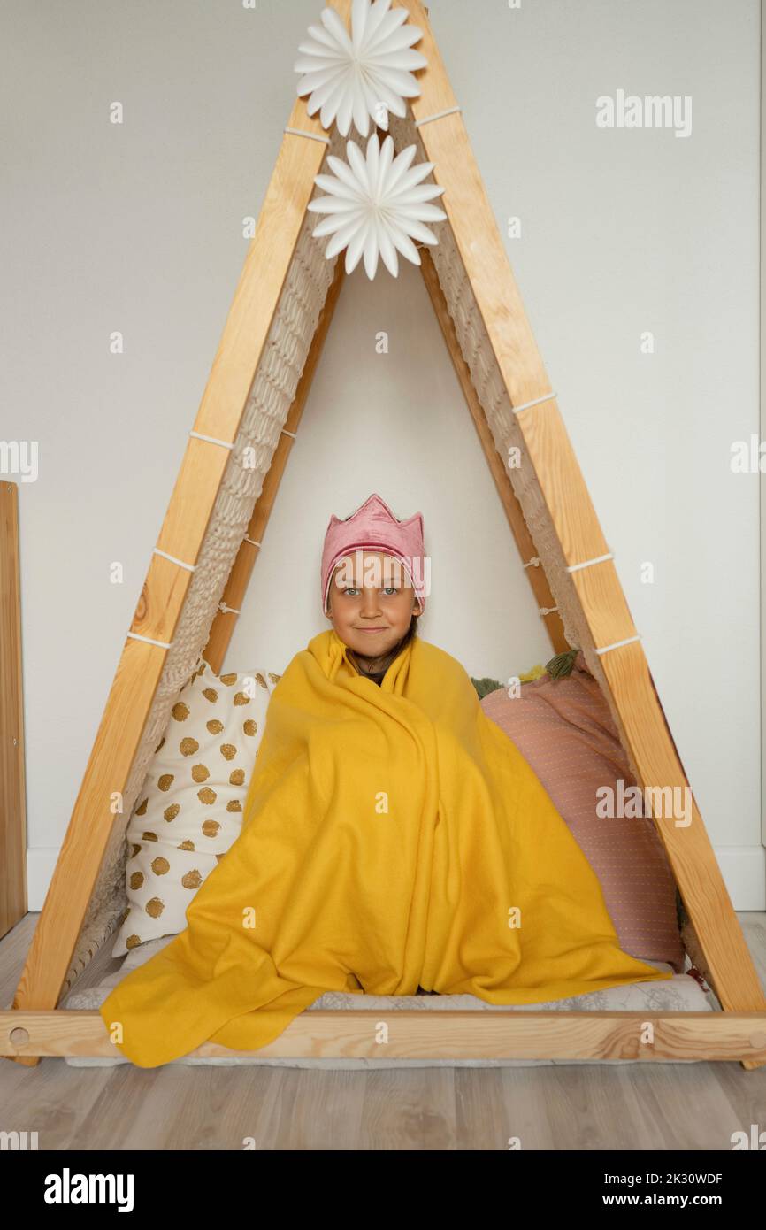 Girl wrapped in blanket sitting inside tent at home Stock Photo Alamy