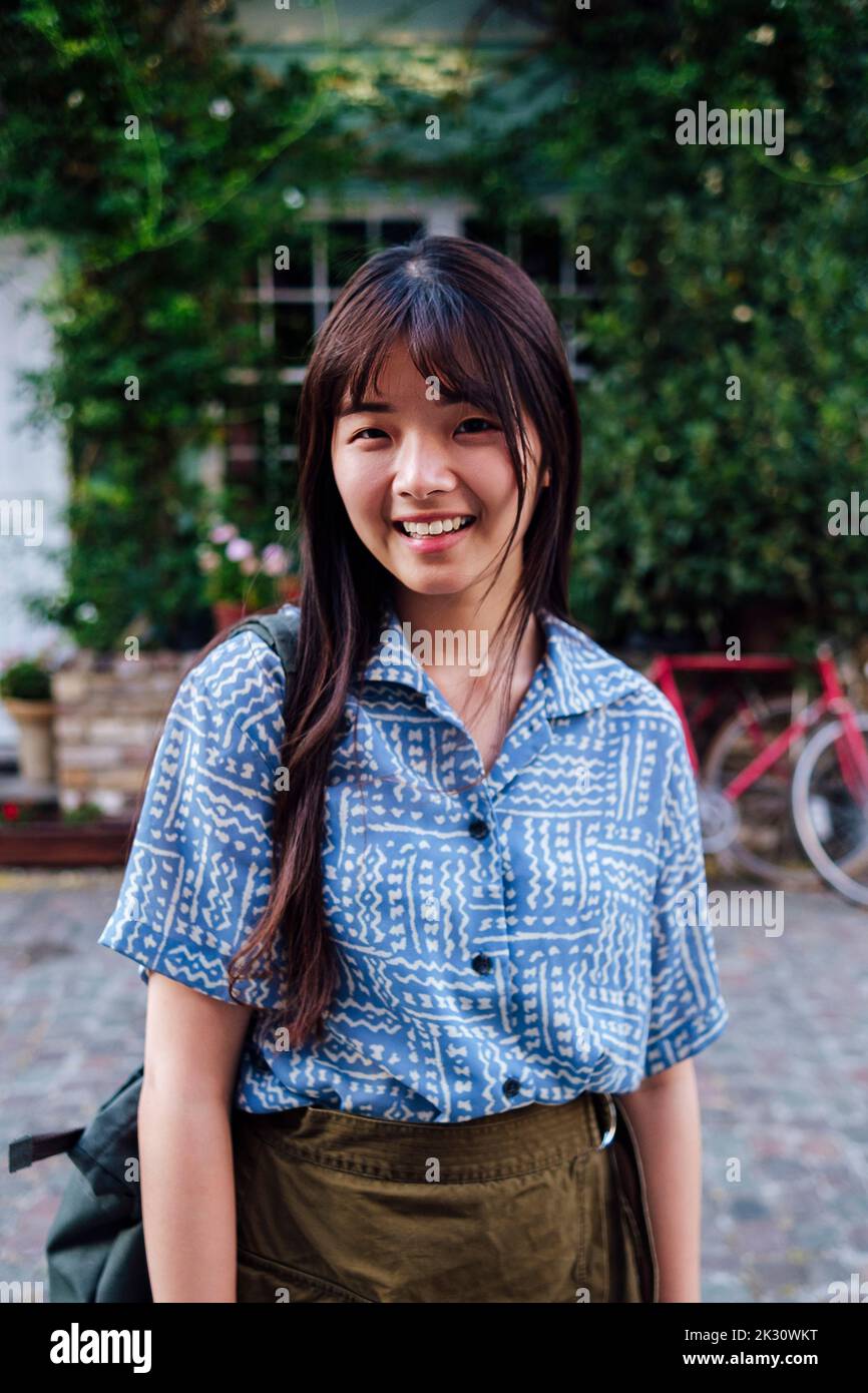 Happy young woman standing on footpath Stock Photo