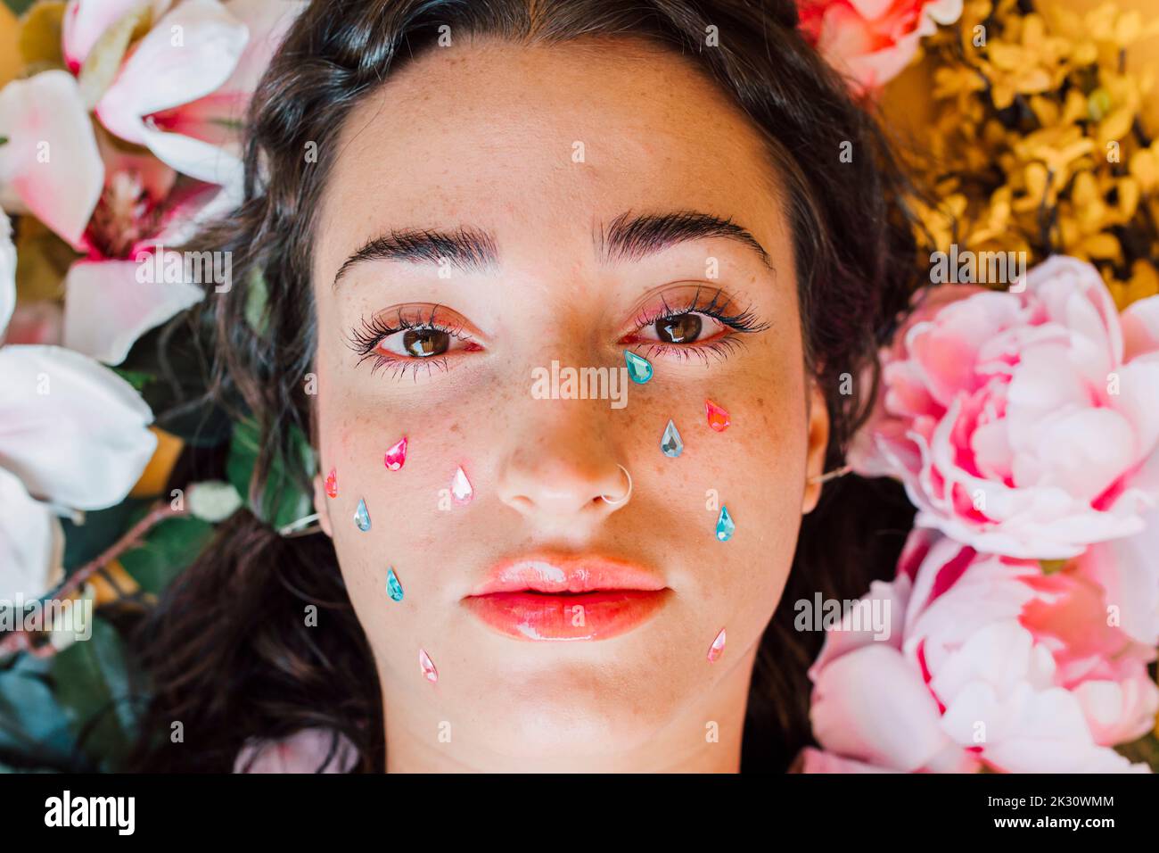 Sad young woman with teardrop stickers on cheeks Stock Photo